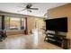 Bright living room with wood floors, a ceiling fan, and large windows overlooking the backyard at 10235 Headrick Dr, Las Vegas, NV 89166