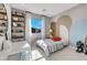 Bright bedroom with a playful mural, shelving unit, and a sunlit window with mountain views at 10332 Stroma Ave, Las Vegas, NV 89166