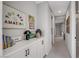 Hallway with built-in white cabinets and drawers adorned with colorful decorations and hallway view at 10332 Stroma Ave, Las Vegas, NV 89166