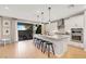 Bright kitchen with island seating, sleek appliances, sliding glass doors to backyard, and wood flooring at 10332 Stroma Ave, Las Vegas, NV 89166