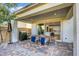 Charming outdoor patio with brick pavers, dining table and chairs, a built-in grill, and a view into the kitchen at 10332 Stroma Ave, Las Vegas, NV 89166