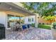 Charming outdoor patio with brick pavers, dining table and chairs, and views into the home's kitchen at 10332 Stroma Ave, Las Vegas, NV 89166