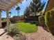 Well-maintained backyard with a lush lawn, mature trees, and a play structure at 10657 San Vercelli Ct, Las Vegas, NV 89141