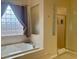 Bright bathroom featuring a soaking tub with window, shower, and neutral tones at 10657 San Vercelli Ct, Las Vegas, NV 89141