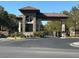 Close-up of the community entrance with a stone gatehouse and manicured landscaping at 10657 San Vercelli Ct, Las Vegas, NV 89141