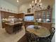 Kitchen with an island, wooden cabinets, and a round dining table with floral decor at 10657 San Vercelli Ct, Las Vegas, NV 89141