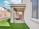 The covered patio is an ideal spot for relaxation and entertaining with an artificial lawn at 10806 Space Odyssey Ave, Las Vegas, NV 89129