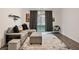 Cozy living room featuring modern sofa, ottoman, and sliding glass doors to the backyard at 10806 Space Odyssey Ave, Las Vegas, NV 89129