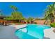 Sparkling pool with a lush backyard, patio, mature trees, landscaping, and a hot tub at 133 S Buteo Woods Ln, Las Vegas, NV 89144