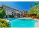 Expansive backyard featuring a pool, patio, lush landscaping, mature trees, and a hot tub at 133 S Buteo Woods Ln, Las Vegas, NV 89144