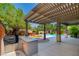 Entertainer's backyard with a pool, pergola, grill, mature landscaping, and hot tub at 133 S Buteo Woods Ln, Las Vegas, NV 89144