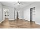 Bright bedroom features wood floors, ceiling fan, walk-in closet, and view to bathroom at 133 S Buteo Woods Ln, Las Vegas, NV 89144