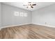 Bright bedroom with wood floors, ceiling fan, and three windows at 133 S Buteo Woods Ln, Las Vegas, NV 89144