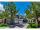 Charming two-story home boasts lush landscaping, a three-car garage, and beautiful architectural details at 133 S Buteo Woods Ln, Las Vegas, NV 89144