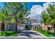 Inviting two-story home featuring drought tolerant landscaping, shade trees, and an attached garage at 133 S Buteo Woods Ln, Las Vegas, NV 89144