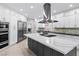 Bright, modern kitchen with a large island, stainless steel appliances, and sleek white cabinetry at 133 S Buteo Woods Ln, Las Vegas, NV 89144