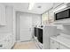 Well-equipped laundry room with modern washer and dryer and plenty of cabinet space at 133 S Buteo Woods Ln, Las Vegas, NV 89144