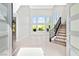 Bright, high-ceiling living room features large windows and a staircase with decorative metal railings at 133 S Buteo Woods Ln, Las Vegas, NV 89144