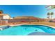 Pool with a cleaner, surrounded by decorative rock, block wall, and houses nearby at 1532 Ascension Cir, North Las Vegas, NV 89031