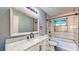 Bathroom with marble countertop vanity, white cabinets, tub/shower combo, and a gray accent wall at 1532 Ascension Cir, North Las Vegas, NV 89031