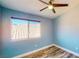 Bright bedroom with wood-look flooring, ceiling fan and large window offering natural light at 1532 Ascension Cir, North Las Vegas, NV 89031