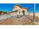 View of home's exterior featuring drought-resistant landscaping, a front yard, and two-car garage at 1532 Ascension Cir, North Las Vegas, NV 89031