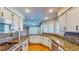 Kitchen with granite countertops, white cabinets, stainless appliances and hardwood flooring with light-filled windows at 1532 Ascension Cir, North Las Vegas, NV 89031