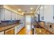 Galley kitchen boasts granite counters, white cabinets, stainless appliances, and hardwood flooring at 1532 Ascension Cir, North Las Vegas, NV 89031