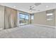 Spacious bedroom with a ceiling fan, balcony access, and neutral carpet at 1536 Unison Way # 102, Las Vegas, NV 89135