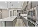 Bright, open kitchen featuring stainless steel appliances, gray cabinets and an island with white countertops at 1536 Unison Way # 102, Las Vegas, NV 89135
