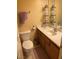 Bathroom with a toilet, single sink vanity, mirror, and open shelving at 1800 Edmond St # 213, Las Vegas, NV 89146