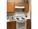 Kitchen features an electric stove, wood cabinets, and a tile backsplash at 1800 Edmond St # 213, Las Vegas, NV 89146