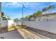 Backyard featuring a paved area, gravel, and white fencing under a blue sky at 2020 Self Portrait St, Henderson, NV 89044