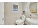 Half bath with a pedestal sink, toilet, window with closed blinds and decorative picture at 2020 Self Portrait St, Henderson, NV 89044