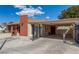 Single-story home showcasing a large driveway, carport, and brick chimney under a bright, sunny sky at 2254 Florence Ave, Las Vegas, NV 89119