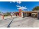 Single-story home showcasing a large driveway, carport, and brick chimney under a bright, sunny sky at 2254 Florence Ave, Las Vegas, NV 89119