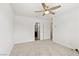 A bedroom featuring a ceiling fan, white walls, carpet flooring, and an attached bathroom at 2677 Saddle Bronze Ct, North Las Vegas, NV 89086