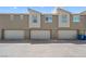 Modern townhome exterior featuring individual garages with neutral color scheme and contemporary design at 2677 Saddle Bronze Ct, North Las Vegas, NV 89086