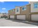 Modern townhome exterior featuring individual garages with neutral color scheme and contemporary design at 2677 Saddle Bronze Ct, North Las Vegas, NV 89086