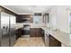 Modern kitchen featuring stainless steel appliances, granite countertops, and dark wood cabinetry at 2677 Saddle Bronze Ct, North Las Vegas, NV 89086