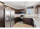 Modern kitchen featuring stainless steel appliances, granite countertops, and dark wood cabinetry at 2677 Saddle Bronze Ct, North Las Vegas, NV 89086