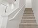 Carpeted staircase leads to the upper level of the home, complemented by a white handrail at 2677 Saddle Bronze Ct, North Las Vegas, NV 89086