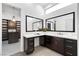 Modern bathroom featuring dual mirrors, dark wood cabinets, and a spacious walk-in closet at 29 Owl Ridge Ct, Las Vegas, NV 89135