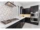 Well-equipped kitchen featuring stainless steel appliances, a gas cooktop, sleek cabinetry, and designer backsplash at 29 Owl Ridge Ct, Las Vegas, NV 89135