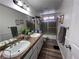 Traditional bathroom featuring a dual sink vanity, framed mirrors, and a shower with patterned glass doors at 2913 Domino Way, Las Vegas, NV 89117