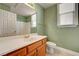Well-lit bathroom with a large mirror, wooden cabinets, and tile flooring at 3071 Misty Moon Ave, Henderson, NV 89052