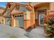 Detailed view of the three-car garage and front entry with a decorative glass door and vibrant bushes at 3071 Misty Moon Ave, Henderson, NV 89052