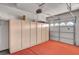 Garage with a red floor and built-in cabinet storage at 3071 Misty Moon Ave, Henderson, NV 89052