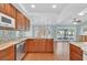 Well-lit kitchen showcases wooden cabinets, stainless steel appliances, granite counters, and sliding door access to outdoors at 3109 Hawksdale Dr, Las Vegas, NV 89134
