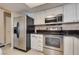 Bright kitchen with stainless steel appliances, white cabinets, and dark countertops at 3350 Duece St, Las Vegas, NV 89121